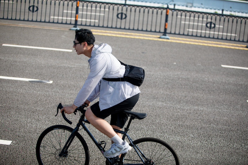 Mark Ryden anti-theft crossbody bag on cyclist riding city road