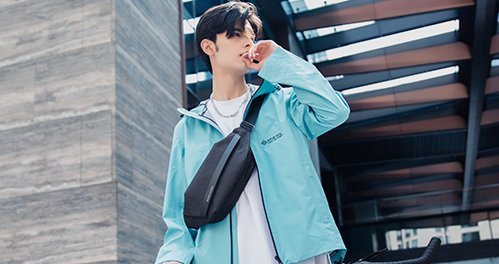 Mark Ryden Global: Model in light blue jacket with black crossbody bag
