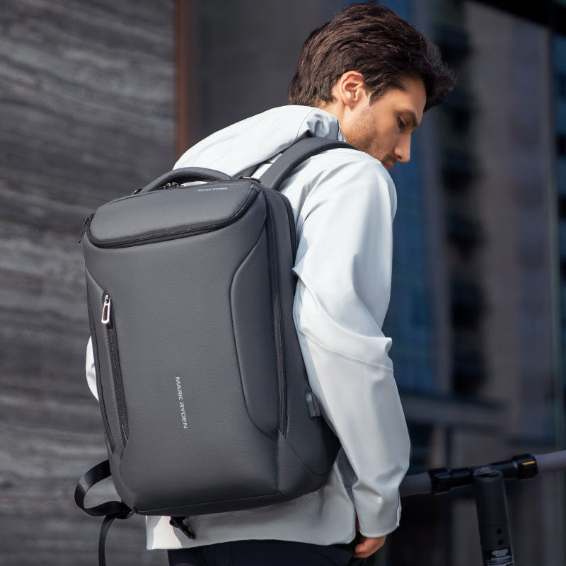 Dark gray Mark Ryden Compacto Pro backpack with sleek design, zippered compartments, worn by a person in an urban setting, featuring anti-theft and travel-friendly features.