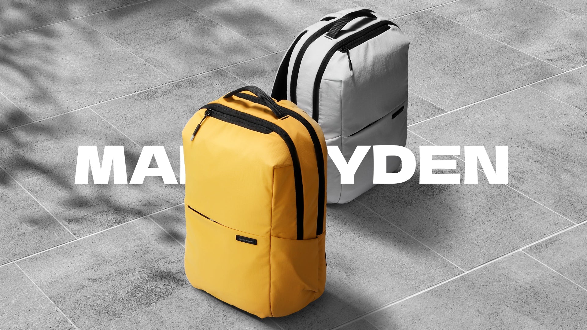 Mark Ryden yellow and gray anti - theft summer backpacks on concrete