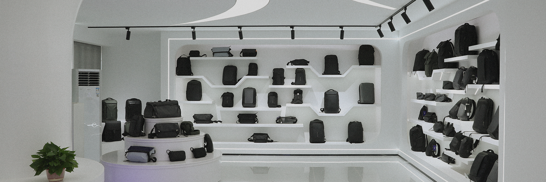 Mark Ryden Global store interior showing black/gray anti-theft custom backpacks on white shelves