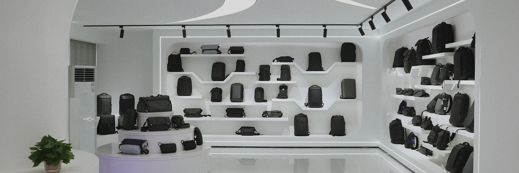 Mark Ryden Global store interior showing black/gray anti-theft custom backpacks on white shelves