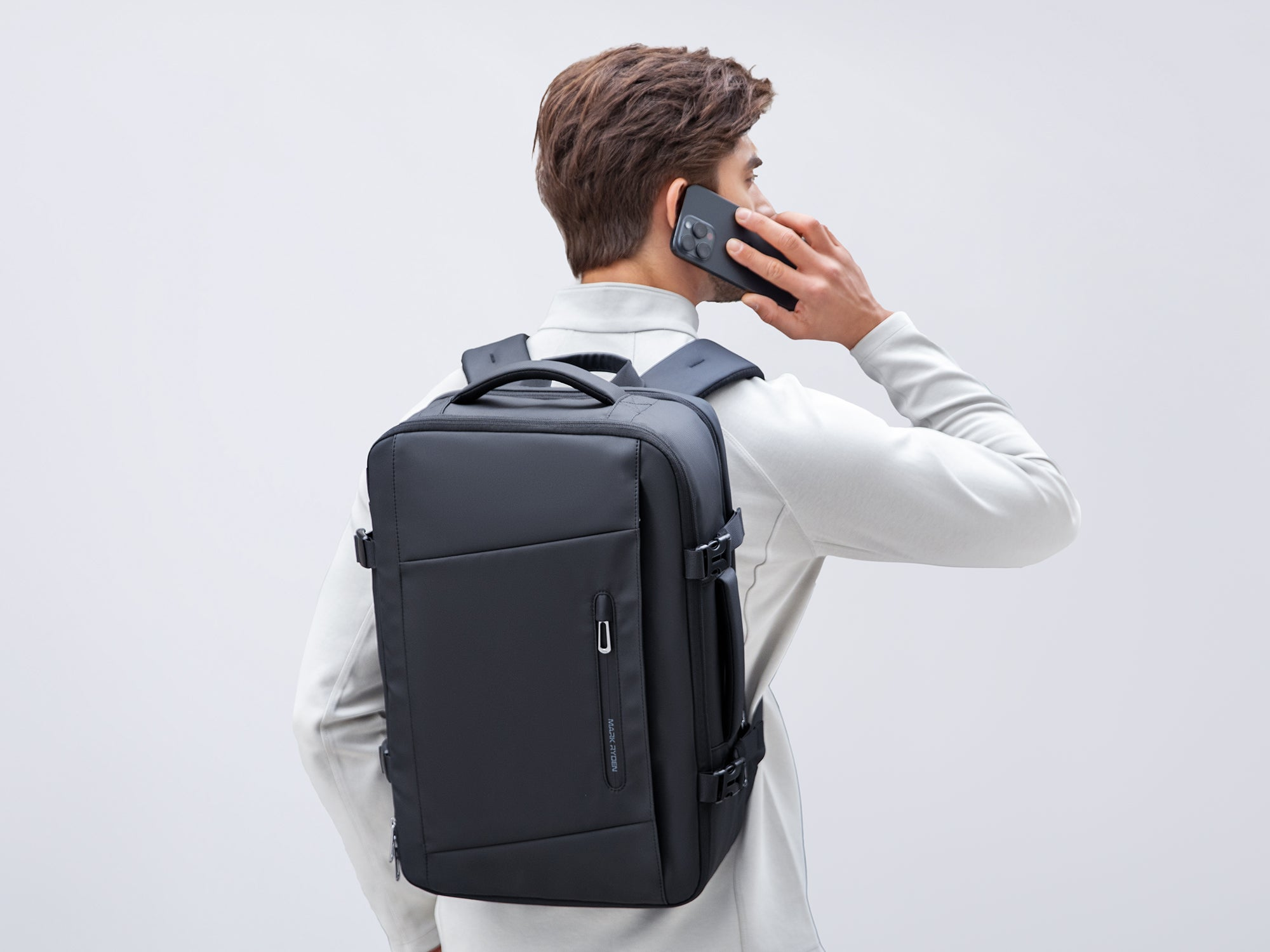 Man talking on phone with Mark Ryden black anti-theft business backpack