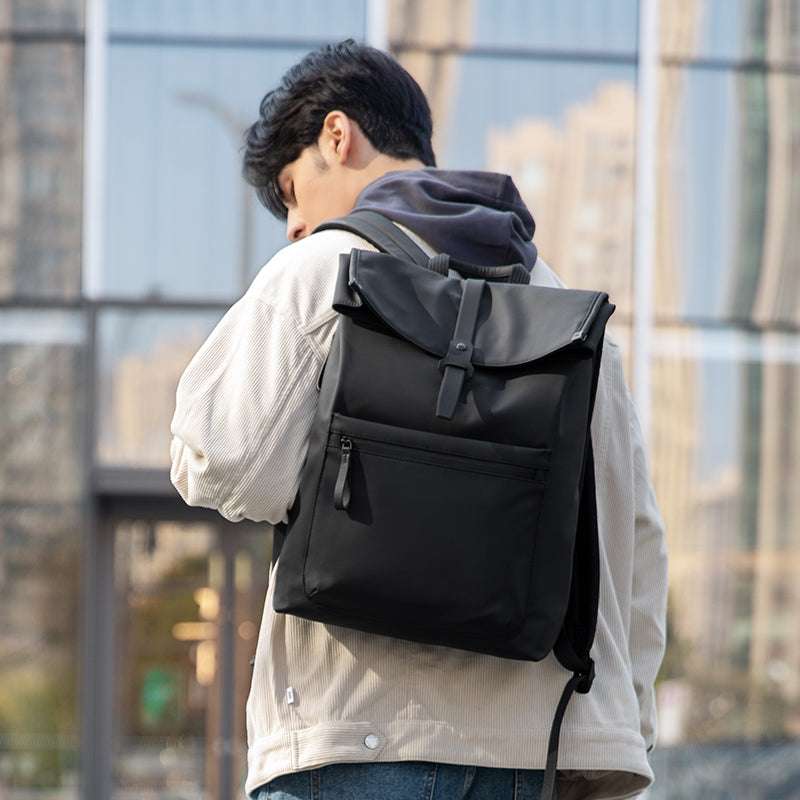 Mark Ryden Global black leather casual multilayer storage backpack worn by man in city
