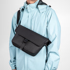 Mark Ryden black crossbody bag on model in light blue jacket - business casual travel style