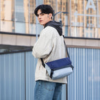 Mark Ryden Global: Youthful navy & gray messenger bag worn by model in urban setting