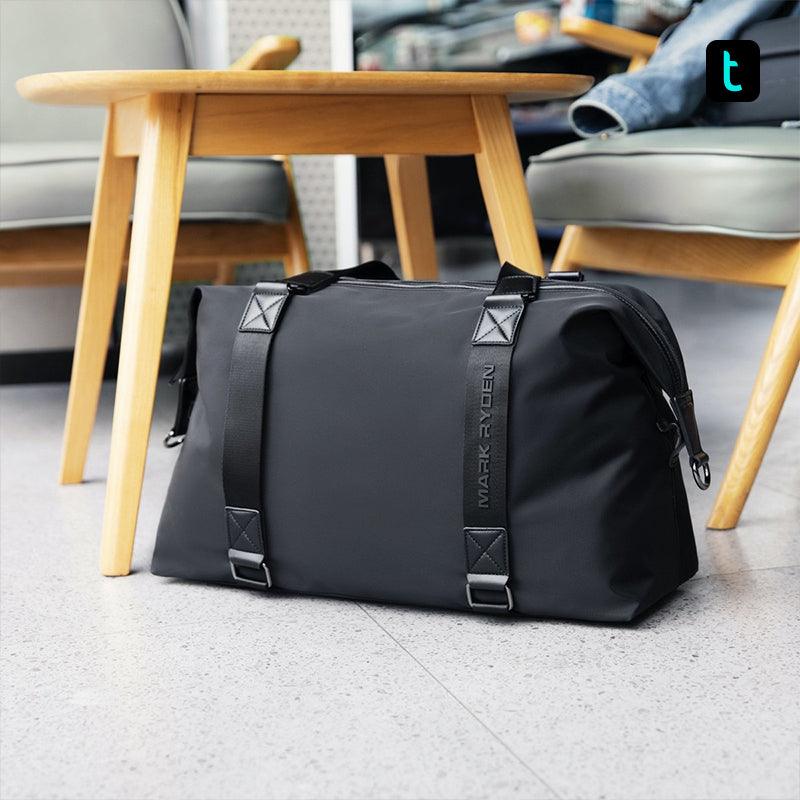 Mark Ryden black lightweight spacious duffel bag near wooden table