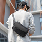 Mark Ryden Global: stylish waterproof crossbody bag with multiple compartments on man in gray sweatshirt