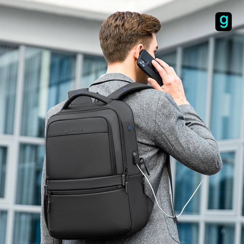 Black Mark Ryden Fady 2nd Gen lightweight laptop backpack with USB charging port and anti-theft pocket, worn by a person with a charging cable connected.