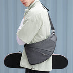 Gray modern urban chest bag by Mark Ryden Global, worn with skateboard