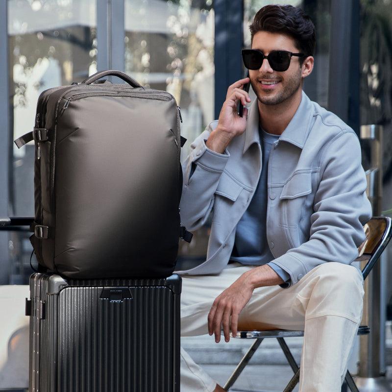 Mark Ryden Global explorer anti-theft backpack on luggage, man talking on phone