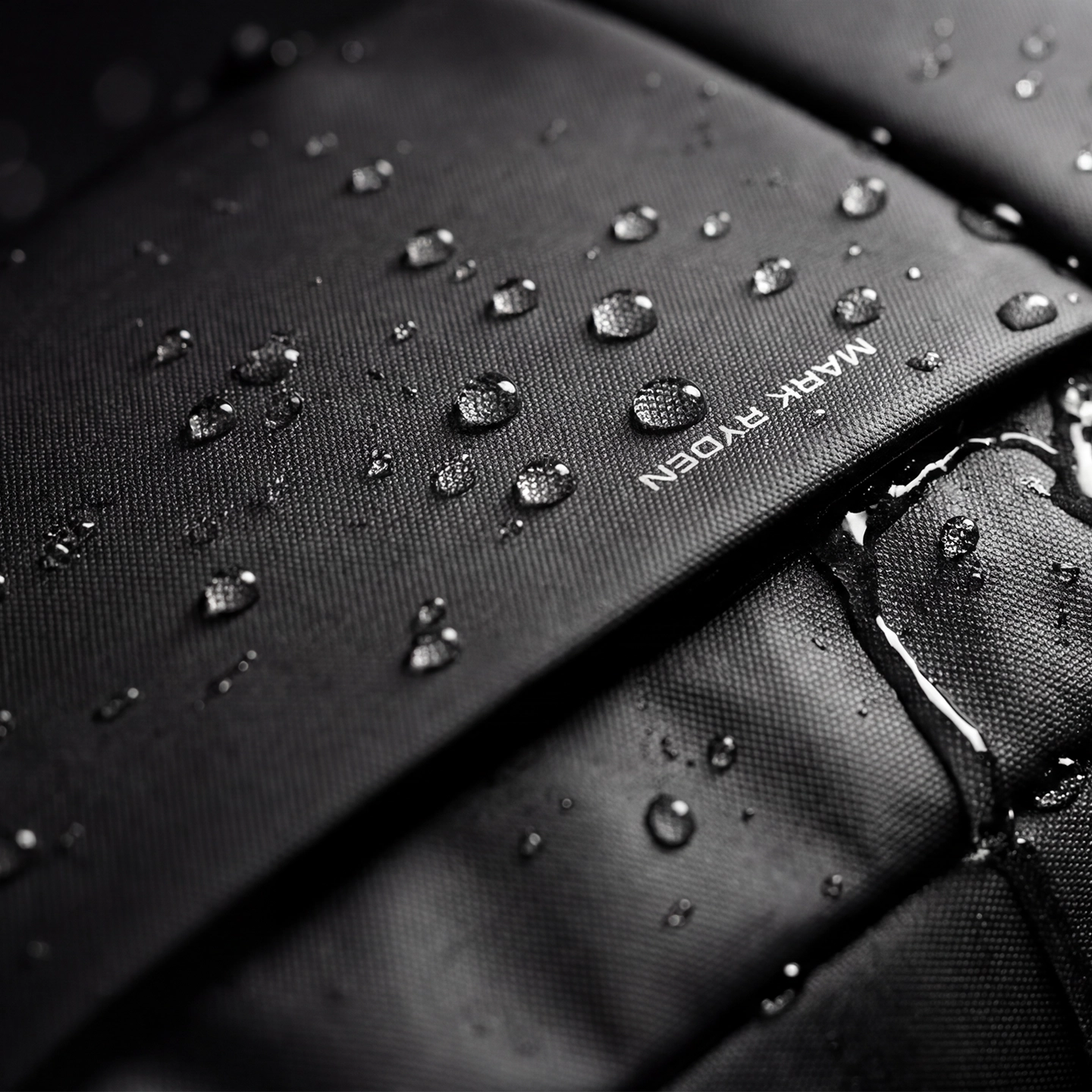 Mark Ryden splash-proof backpack with water droplets showcasing durability