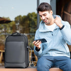 Man using smartphone connected to black LeatherLux premium backpack outdoors