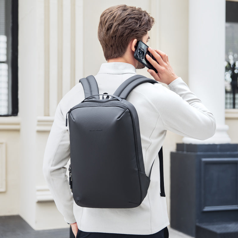 Man wearing black ZenOrganizer compact laptop backpack while talking phone