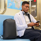 Mark Ryden Global black compact laptop backpack on subway seat for daily use