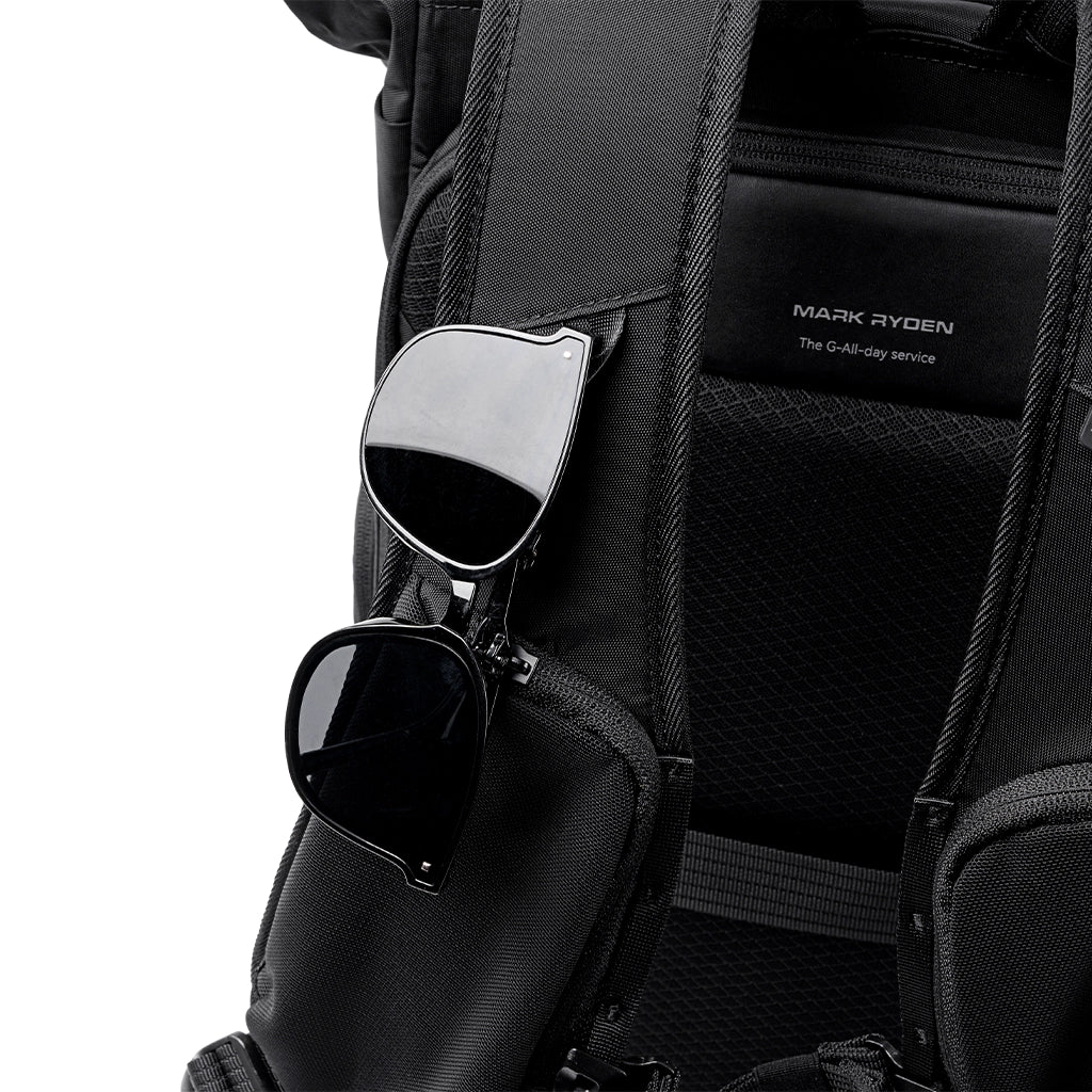 Black Mark Ryden MorphCore 27-36L adaptive expandable backpack with sunglasses in front pocket, designed for travelers.