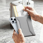 MagiPass gray mesh crossbody wallet with boarding pass and phone near silver suitcase