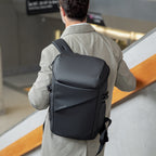 Mark Ryden AeroShield 2025 innovative black durable waterproof backpack with sleek structured design, worn by man in modern indoor setting.