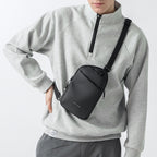 Mark Ryden Global ProCarry black anti-theft sling bag on model in gray sweater